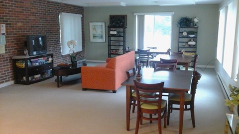 A living room with a brick wall and a television.