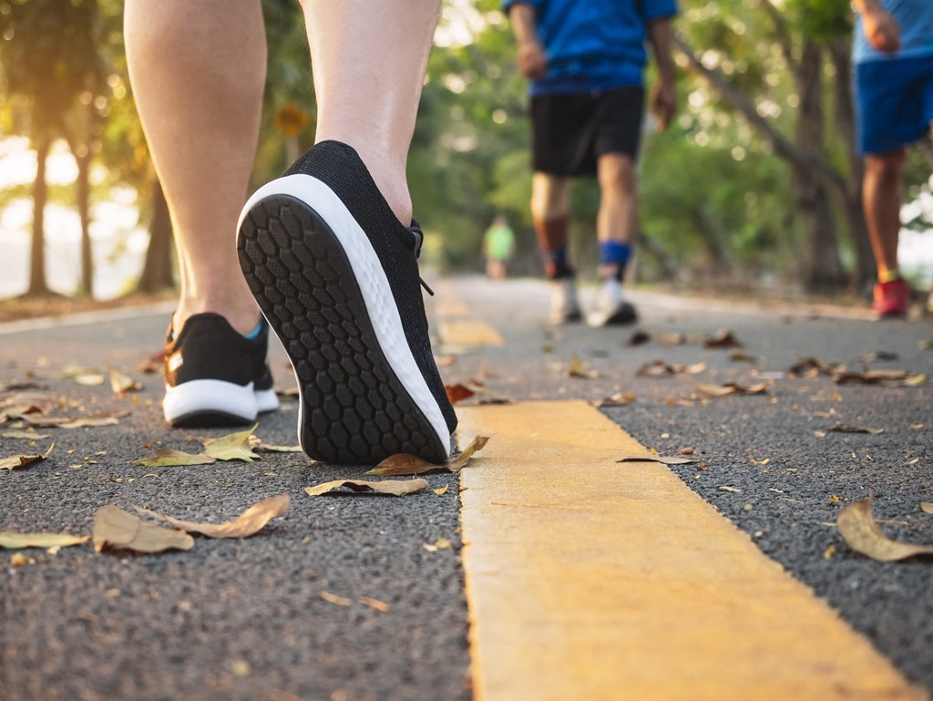 A person is walking on a road with a yellow line.