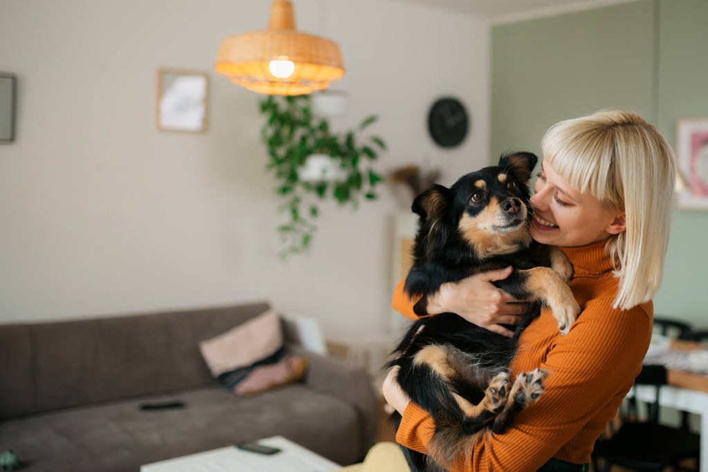 A woman is holding a dog in her arms.