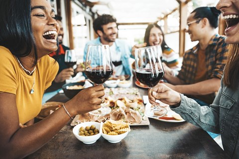 A group of people are enjoying a meal and drinks together at a table.