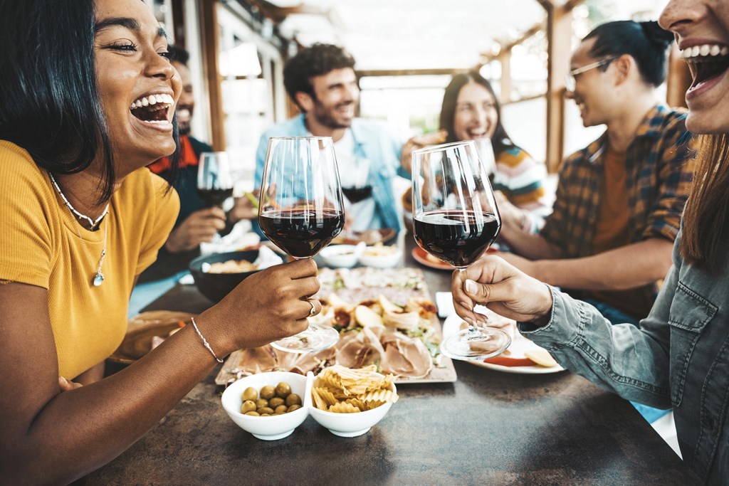 A group of people are enjoying a meal and drinks together at a table.