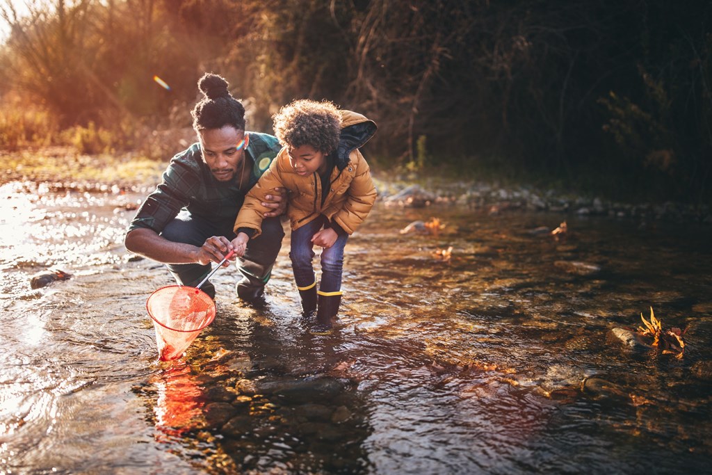 Two people are fishing in a river.