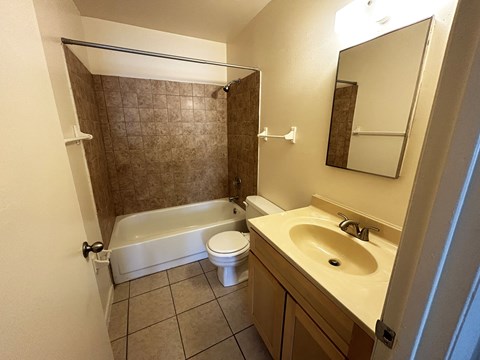 A bathroom with a white tub, sink, and toilet.