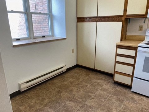 an empty kitchen with a stove and a window