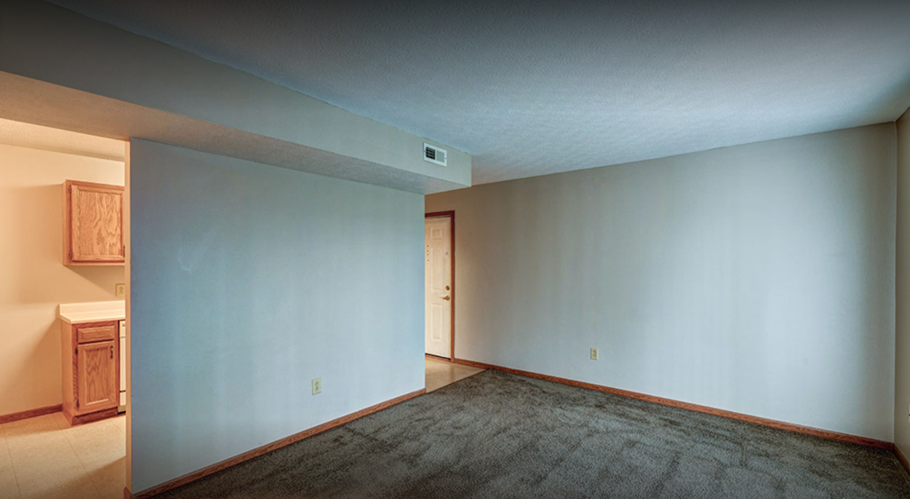 a living room with a carpet and a blue wall