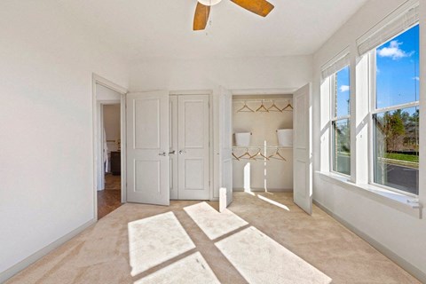 a living room with a large window and a ceiling fan