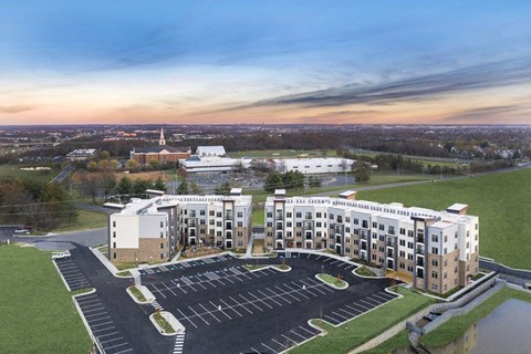 an aerial view of an apartment building and parking lot