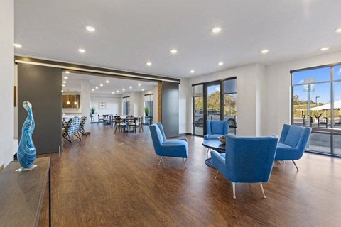a large living room with blue chairs and a wooden floor