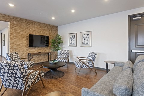 a living room with a couch and chairs and a television