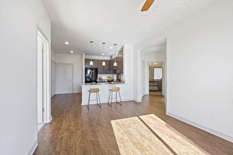 an open kitchen and living room with a kitchen island and stools