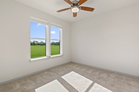 an empty room with a window and a ceiling fan