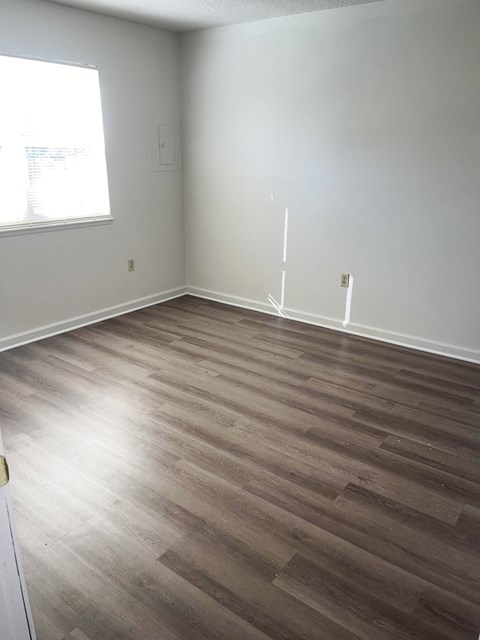 A room with wooden flooring and a window.