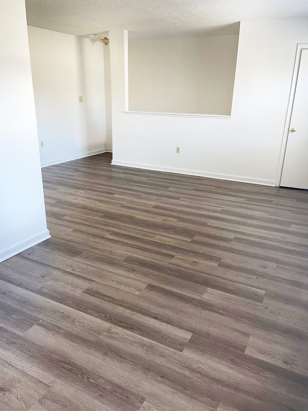 A room with wooden flooring and white walls.