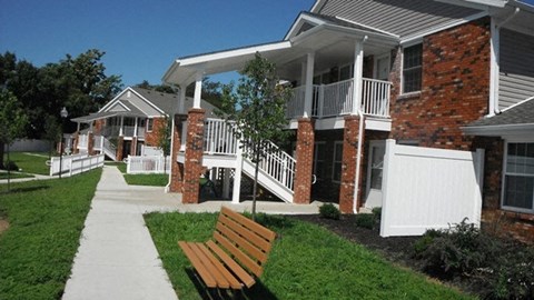 a row of houses with a wooden bench in front of them