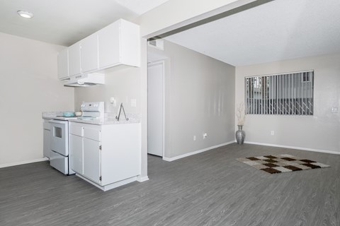 A kitchen with white cabinets and a white fridge.