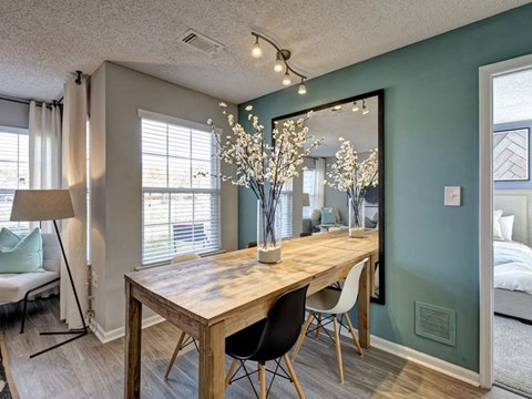 A dining room with a wooden table and chairs.