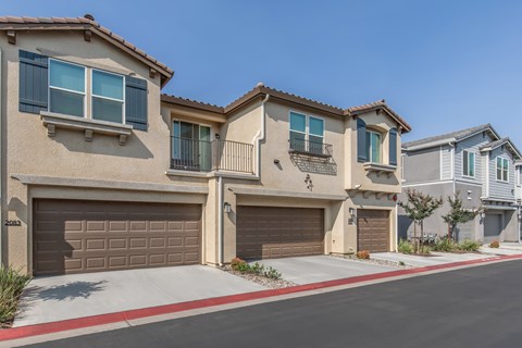 A row of houses with garages and driveways.
