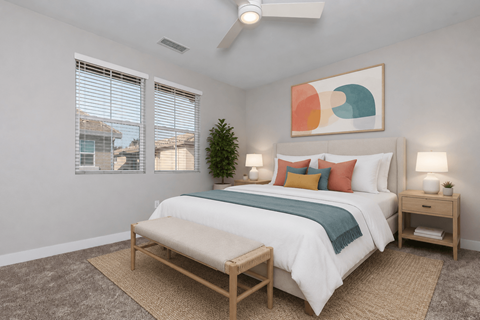 A bedroom with a bed, nightstands, and a ceiling fan.