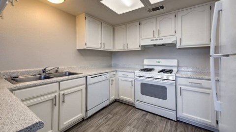 A kitchen with white appliances and cabinets.