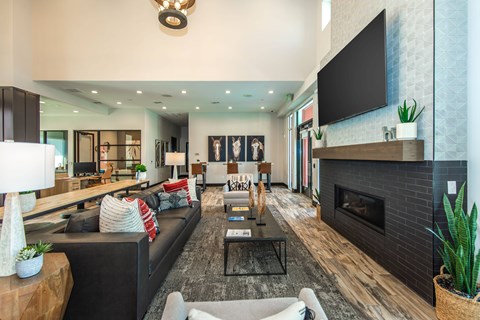 A modern living room with a fireplace and a flat screen TV mounted on the wall.