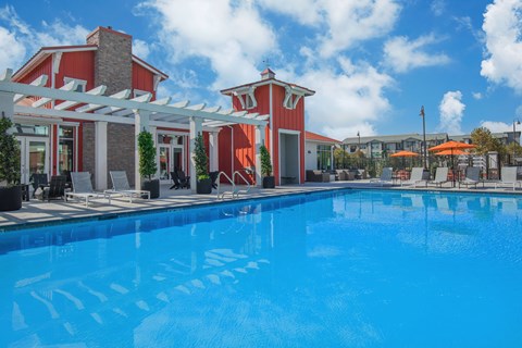 A large swimming pool in front of a red and white building.
