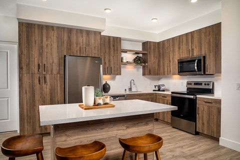 A modern kitchen with wooden cabinets and a white island.