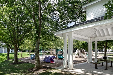 A playground with a white pavilion and a slide.