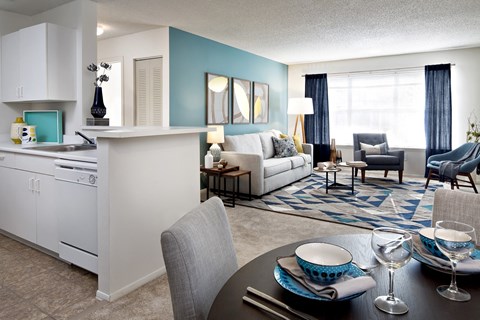 A modern kitchen with a dining table set for two.