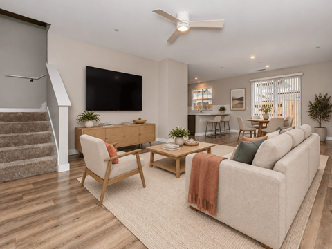 A living room with a couch, chairs, and a television.