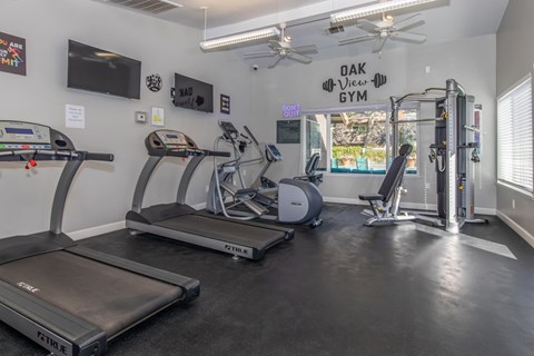 A gym with treadmills, exercise bikes, and a weight machine.