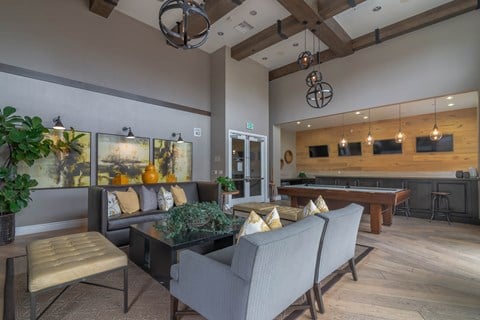 A living room with a pool table and a bar area.