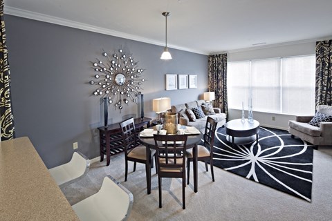 A dining room with a table set for six and a chandelier hanging from the ceiling.