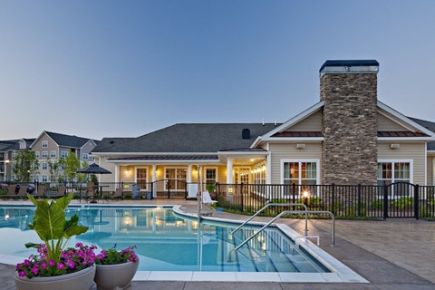 A house with a pool in front of it.