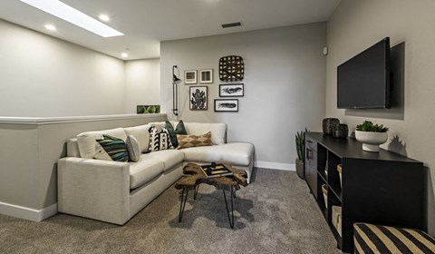 A living room with a white couch and a black TV.