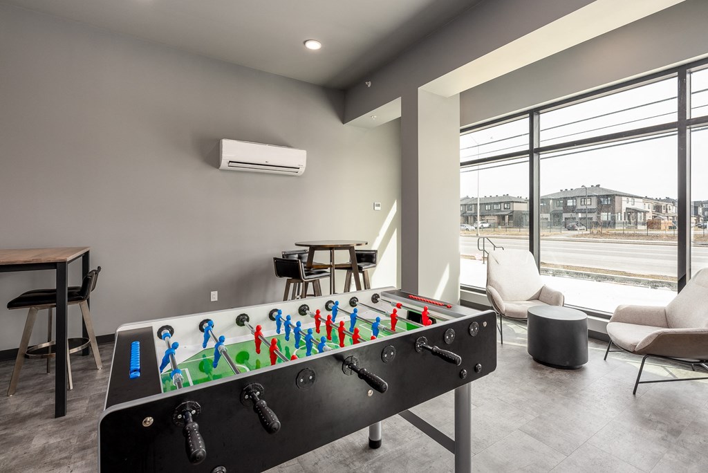 a game room with a foosball table and a window