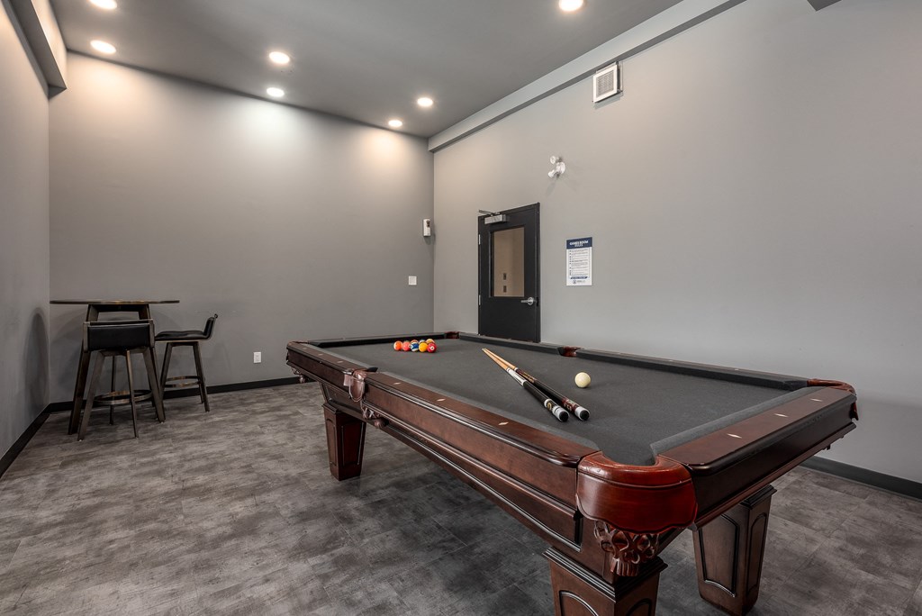 a game room with a pool table and a bar