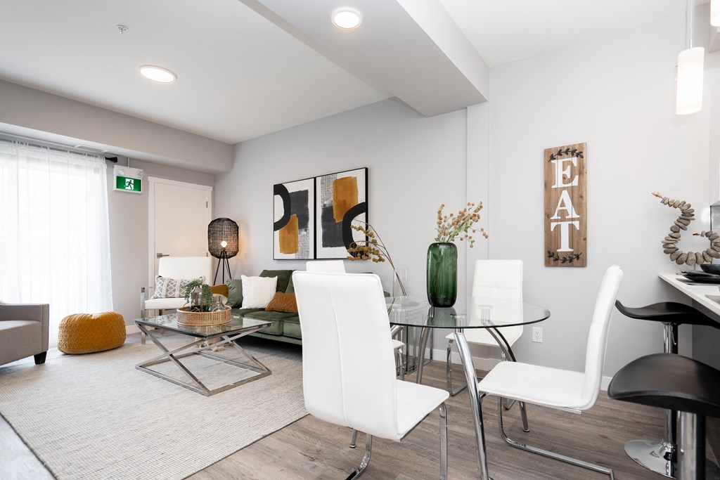 a dining area with a glass table and white chairs