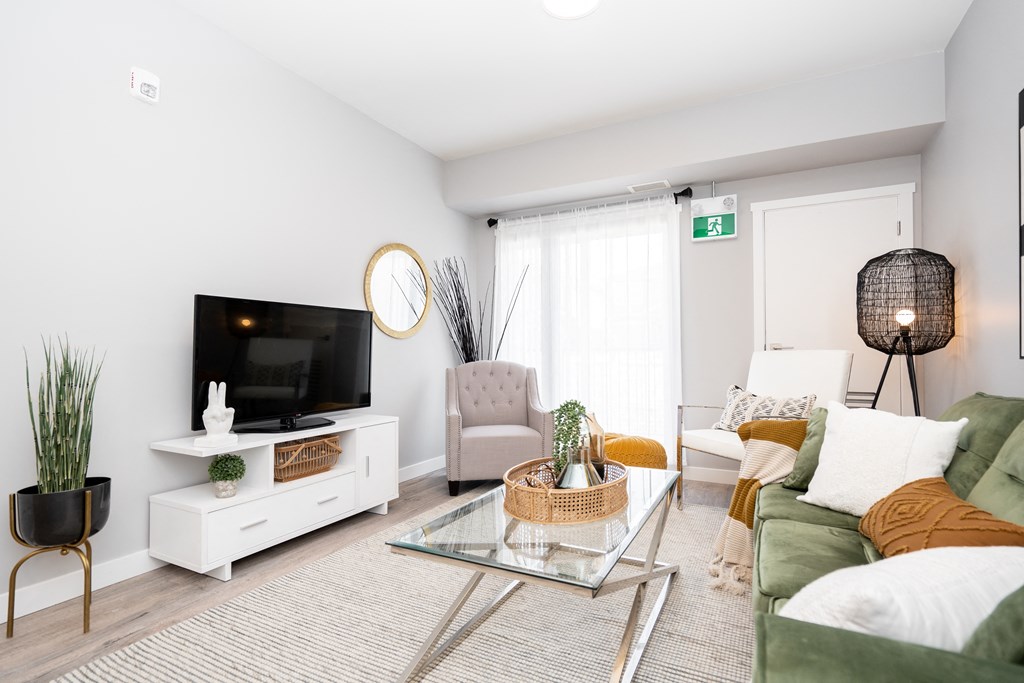 a living room with a green couch and a glass coffee table