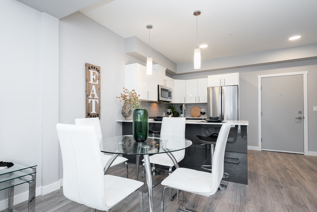 a dining area with a glass table and white chairs