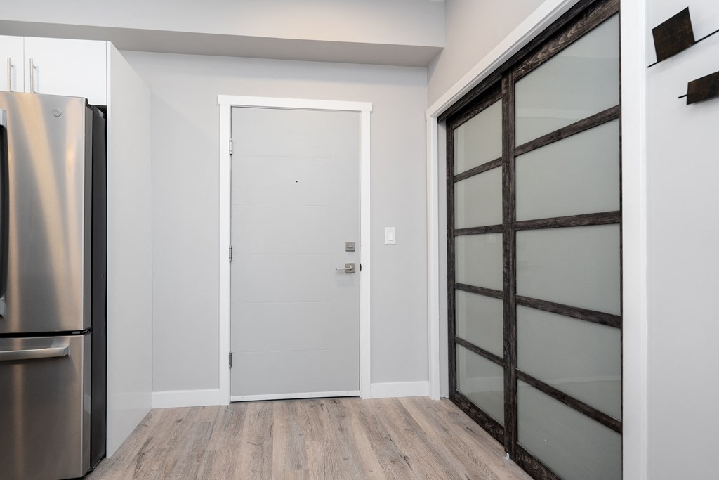 a bedroom with a medium sized bed and a refrigerator in a room