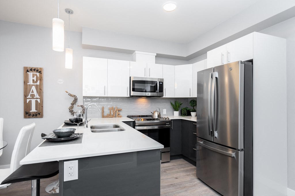 a kitchen with white countertops and stainless steel appliances