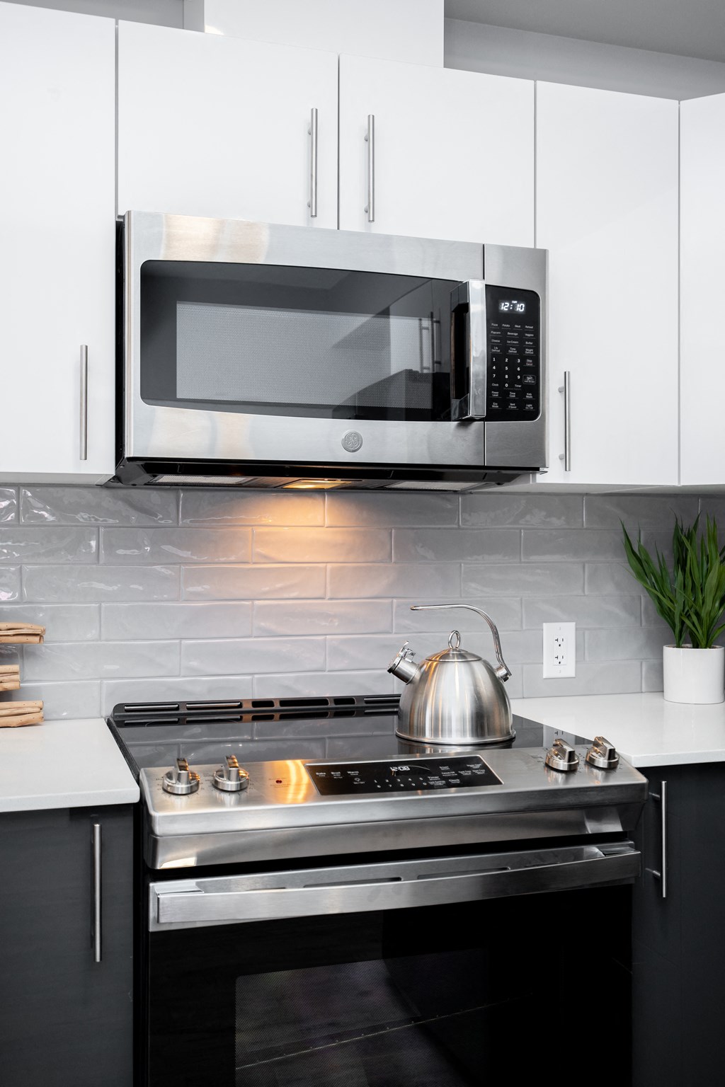 a kitchen with white cabinets and a stainless steel microwave above the stove