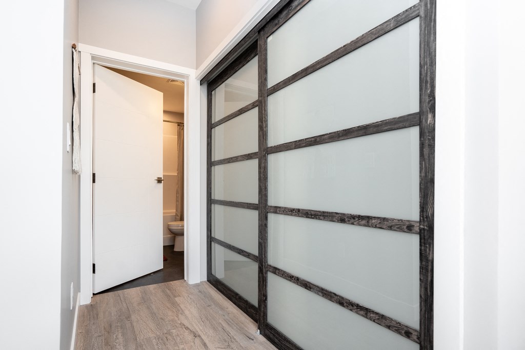 a sliding glass door in a bathroom with a toilet in the background