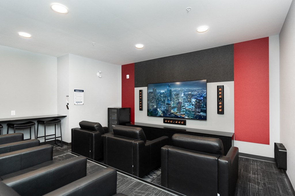 a living room with leather chairs and a tv on the wall