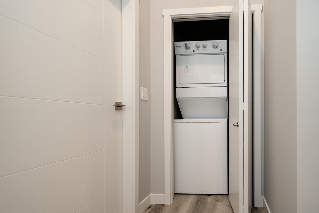 a small white refrigerator and stove in a room with a door