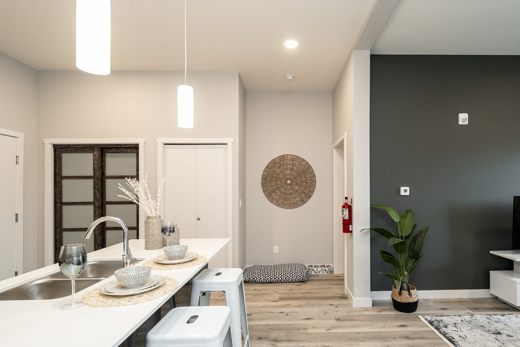 a kitchen and living room with a white counter top and a sink