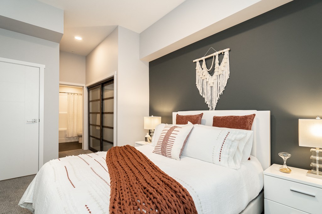 a bedroom with a white bed and a grey accent wall