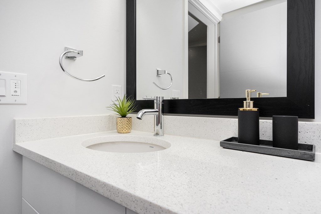 a white bathroom with a sink and a mirror