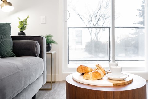 a living room with a tray of croissants on a table and a couch