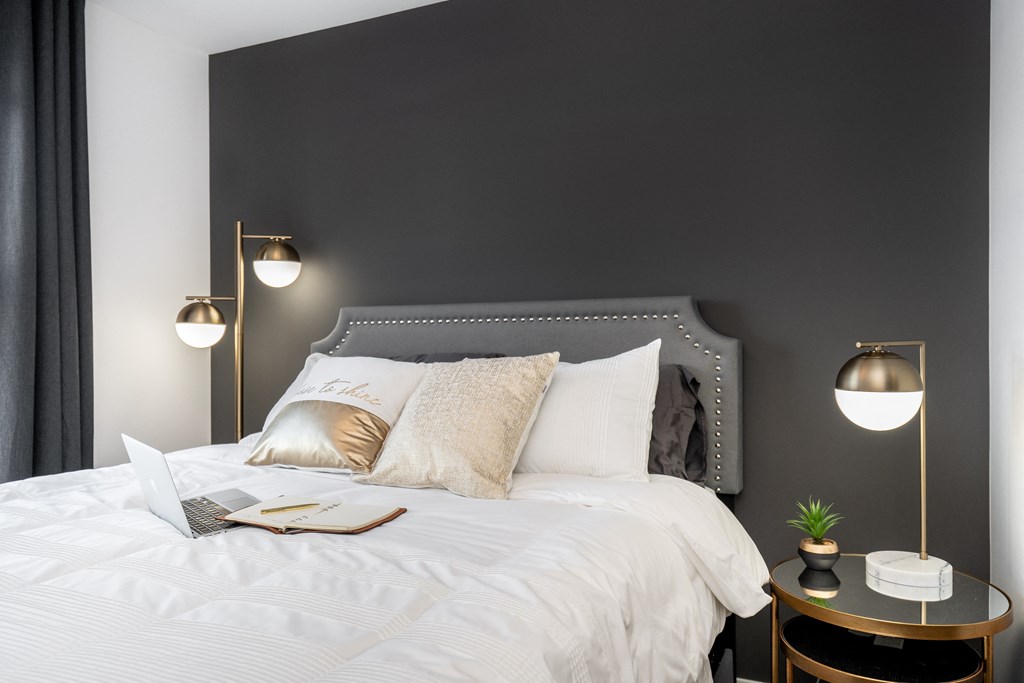 a bedroom with a bed with a laptop on it